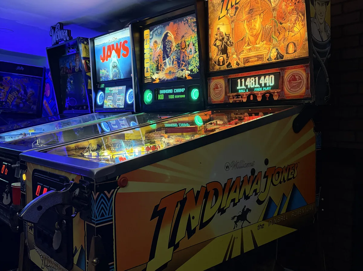 Pinball machines for sale on the shop floor, including an Indiana Jones