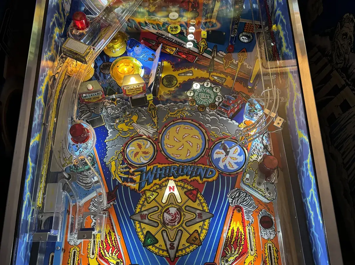 A Williams Whirlwind playfield lit up in the shop